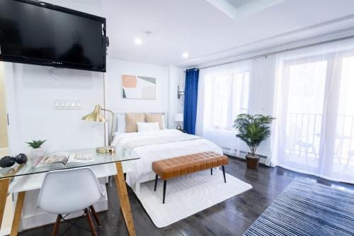 ニューヨークにある809-5b Luxury Studio with a Private Balconyの白いベッドルーム(大型ベッド1台、デスク付)