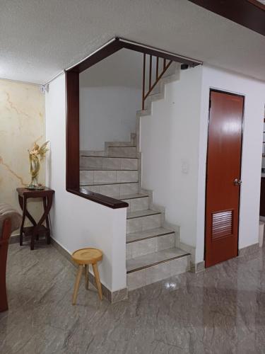 a staircase in a room with a door and a stool at El Palmar in Palmira