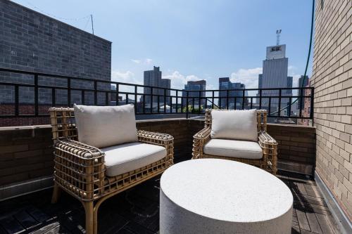 two wicker chairs and a table on a balcony at 809-6B New 2BR Duplex With Private Patio in New York
