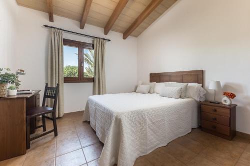 Un dormitorio con una cama y un escritorio y una ventana. en Son Sea Villa, en Campos