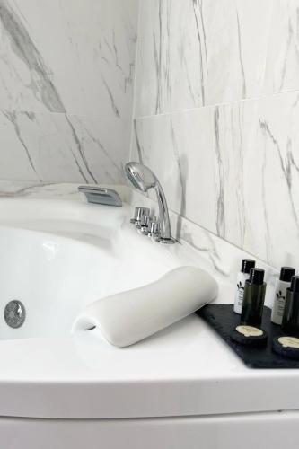 - un lavabo blanc dans la salle de bains avec un porte-brosse à dents à côté dans l'établissement Hôtel Le domaine de Montmorency, à Montmorency