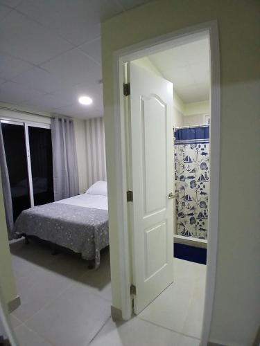 a door leading to a bedroom with a bed in it at casa de playa vacacional goldsky in Vista Alegre