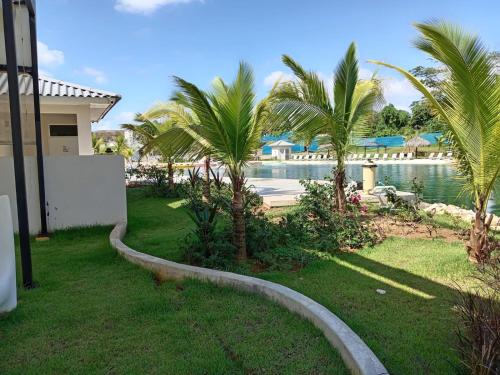 a yard with palm trees and a swimming pool at casa de playa vacacional goldsky in Vista Alegre