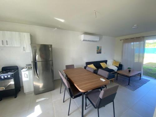 a kitchen and dining room with a table and a refrigerator at casa de playa vacacional goldsky in Vista Alegre