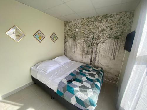 a small bed in a room with a painting on the wall at casa de playa vacacional goldsky in Vista Alegre