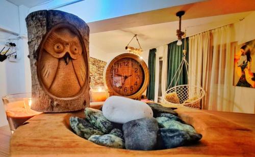 a table with an owl clock and rocks on it at Rosa Apartment in Drobeta-Turnu Severin