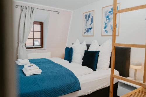 Un dormitorio con una cama azul y blanca y una escalera en JINO Königstein l Elbblick - WLAN - stilvoll, en Königstein