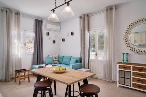 a living room with a blue couch and a table at Aroma Kastellia - Althea Homes in Amoopi
