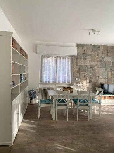a white dining room with a table and chairs at Appartamento caneve in Arco