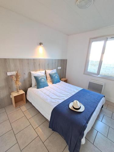 une chambre avec un lit avec un chapeau dessus dans l'établissement La Maison des Coquilles, à Lanton