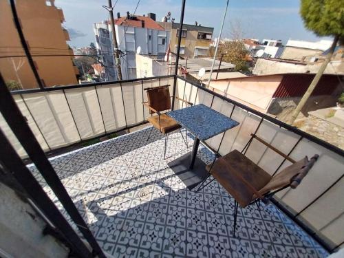 a balcony with two chairs and a table on top at Tiyn house in Konak