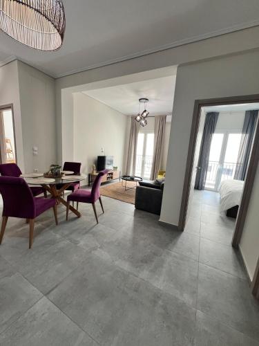 a living room with a table and chairs and a couch at Feels Like Home 2 - Agrinio Suites in Agrinion