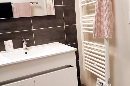 une salle de bain avec un lavabo blanc et un miroir dans l'établissement T2 avec terrasse proche de la plage de Royan dans le Quartier du Parc, à Royan