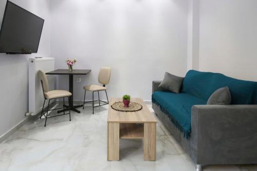 a living room with a blue couch and a table at #D Ioanna Apartments in Thessaloniki