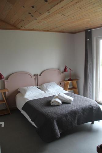 a bedroom with a large bed with a wooden ceiling at Le Saint-Germain - Maison en bois en pleine nature in Saint-Germain-Chassenay