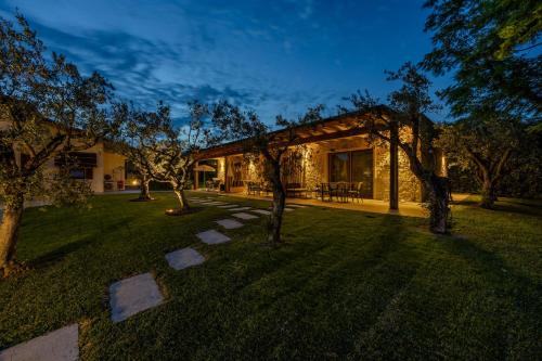 a house with a yard with trees in front of it at Villa Maddalena in Bardolino