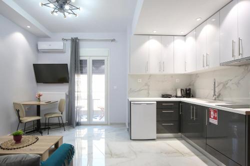a kitchen with white cabinets and a table in a room at #C Ioannas Apartments in Thessaloniki