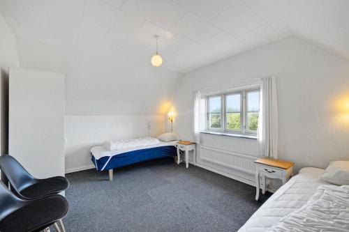 Una pequeña habitación con dos camas y una ventana. en Jørgen's Feriehus, en Lemvig