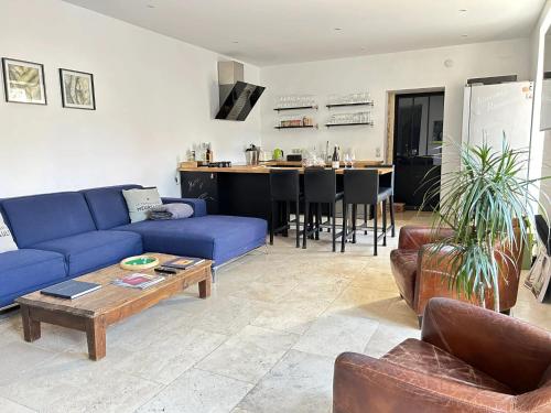 un salon avec un canapé bleu et une table dans l'établissement Maison élégante à Meursault avec jardin clos et cheminée, à Meursault
