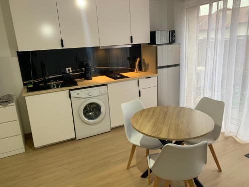 a kitchen with a table and a washing machine at Appartement confortable et cosy près de Braga in Pico