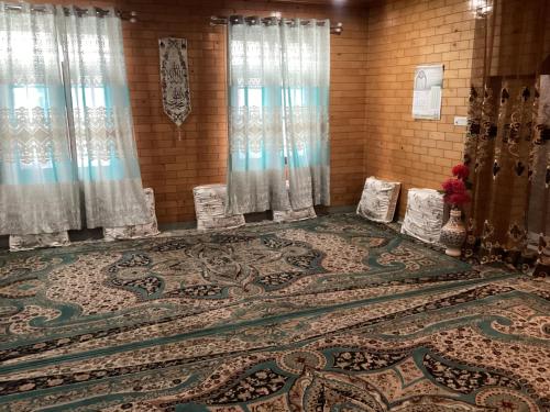 una stanza con un grande tappeto sul pavimento con tende di VisitingVillah a Srinagar