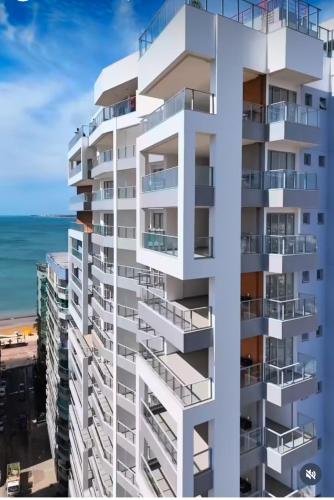 a rendering of a tall white apartment building overlooking the beach at Apartamento NOvo na Praia do Morro Temporada Wi-Fi, Vista Mar, garagem, varanda grande in Guarapari