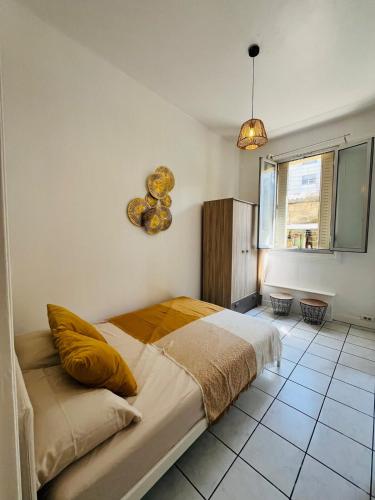 une chambre avec un grand lit avec des oreillers jaunes dans l'établissement Spacious and Modern Studio, à Nice