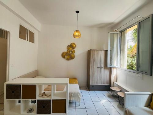 Cette chambre blanche dispose d'une table et d'une fenêtre. dans l'établissement Spacious and Modern Studio, à Nice