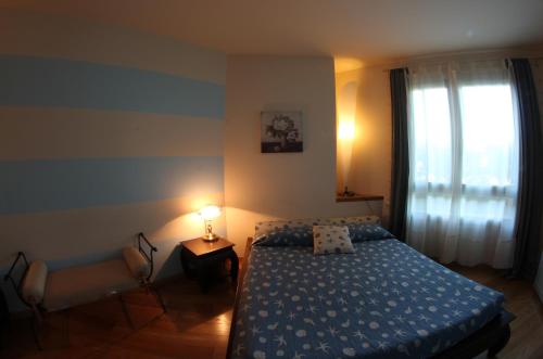 a bedroom with a bed and a lamp and a window at Bombyx Inn in Bergamo