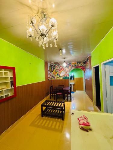 a dining room with a table and a chandelier at Greenwoods Munnar Unmarried Allowed in Munnar