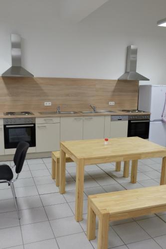 a kitchen with a wooden table and benches in it at Montagehotel Bed & Steel in Linz