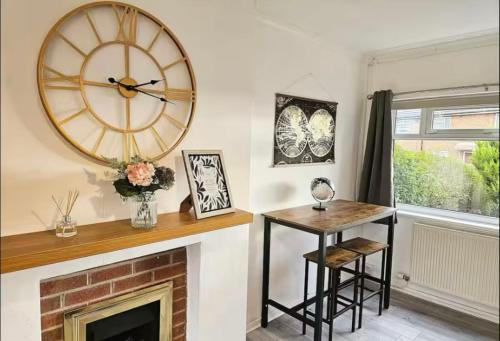 a living room with a clock and a fireplace at 3 Stars Grètopp house in Little Hulton
