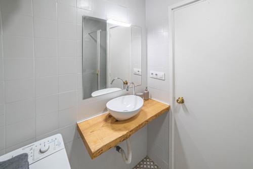 Un baño con un lavabo blanco y un espejo. en Welcomy Sant Andreu, en Barcelona