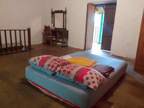 a bed with colorful pillows on it in a room at Habitación en casa de campo via al aeropuerto in Copacabana