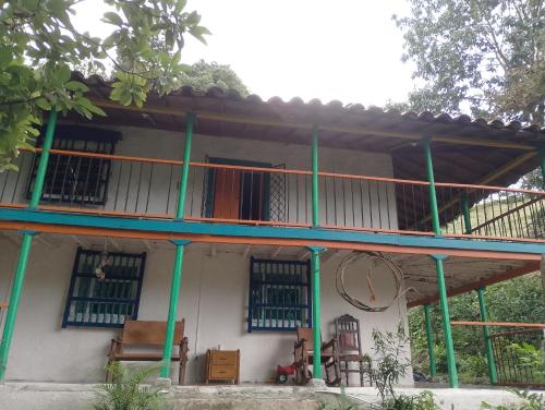 a house with a balcony with chairs in front of it at Habitación en casa de campo via al aeropuerto in Copacabana