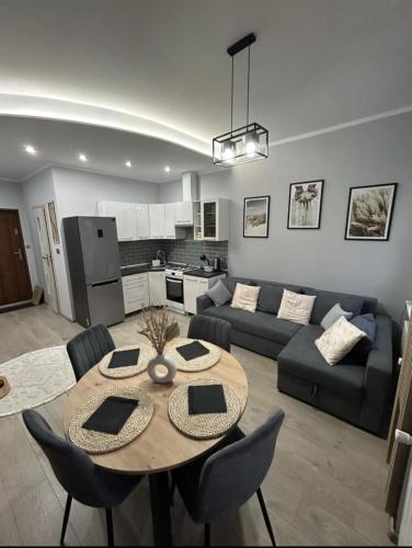 a living room with a table and a couch at Landsberg Studio Apartment in Górowo Iławeckie