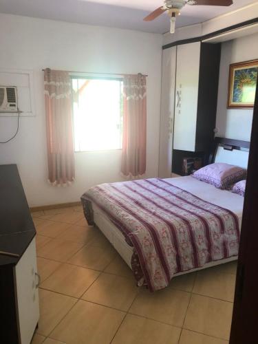 a bedroom with a large bed and a window at Casa de campo em Gaspar in Gaspar
