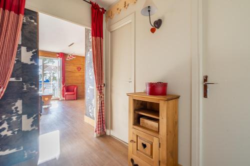 a hallway with a wooden cabinet and a door at Appartements T2 et T3 L'esprit chalet au coeur du centre ville et 80 m de la télécabine in Font-Romeu