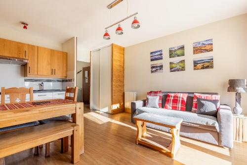 un salon avec un canapé et une table dans l'établissement Appartements T2 et T3 L'esprit chalet au coeur du centre ville et 80 m de la télécabine, à Font-Romeu