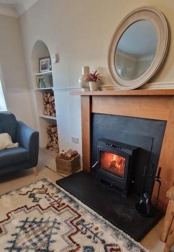 a living room with a fireplace with a mirror at North Coast Property - Avoch Beach House - Luxury house with sea views in Avoch