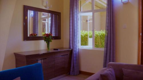 a room with a mirror and a dresser and a window at La Casa Savanna in Naivasha