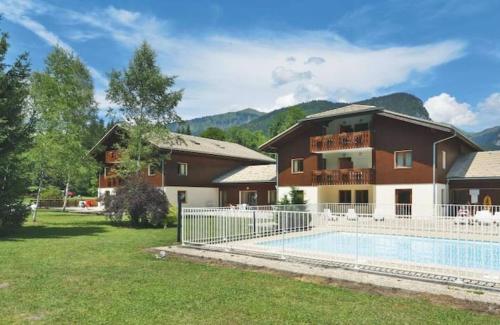 une maison avec une piscine devant une maison dans l'établissement Studio Résidence grand tetras, à Samoëns
