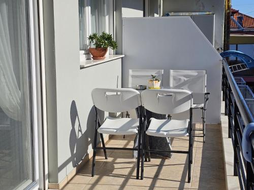 a table and two chairs on a balcony at Tania Apartments in Leptokaria