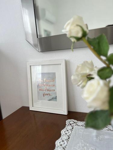 a picture on a table next to a vase with flowers at 2-bedroom apartment ILLARIO - heart of Tuscany - airco & free parking in Pomarance