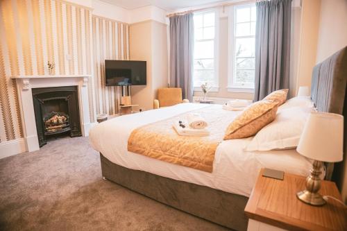 a bedroom with a large bed and a fireplace at St Michaels Town House - Elegant and Large Holiday Home in the Heart of Gloucester in Gloucester