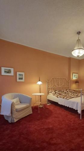 a bedroom with a bed and a chair and a table at City-Ferienwohnungen-Dresden - zentral gelegen im Haus Louisenstrasse 11 - Dresden-Neustadt in Dresden