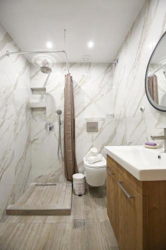 a bathroom with a toilet and a sink and a mirror at #B Ioanna's Apartments in Thessaloniki