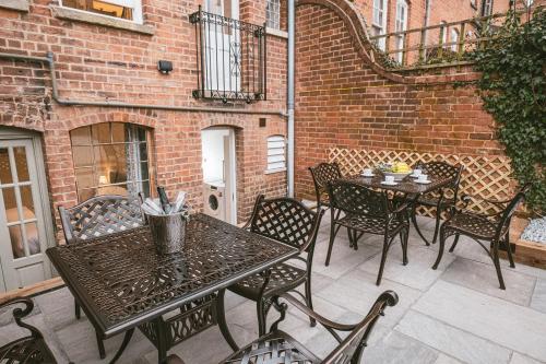 a patio with a table and chairs and a brick building at St Michaels Town House - Elegant and Large Holiday Home in the Heart of Gloucester in Gloucester