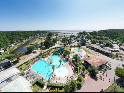 une vue aérienne d'une piscine dans un complexe hôtelier dans l'établissement Lodge du Sangla Mobil Home premium Village Vacances 4 étoiles Lège Cap Ferret, à Lège-Cap-Ferret