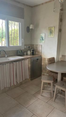 - une cuisine avec un évier et une table dans l'établissement villa calme, à Saint-Aygulf
